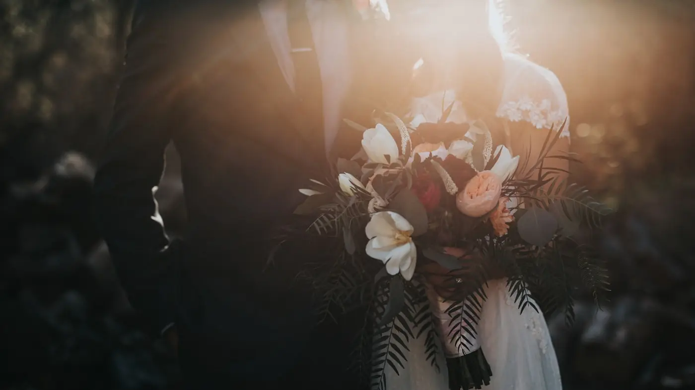 Wedding photographer's image of a bride holding a bouquet in low light